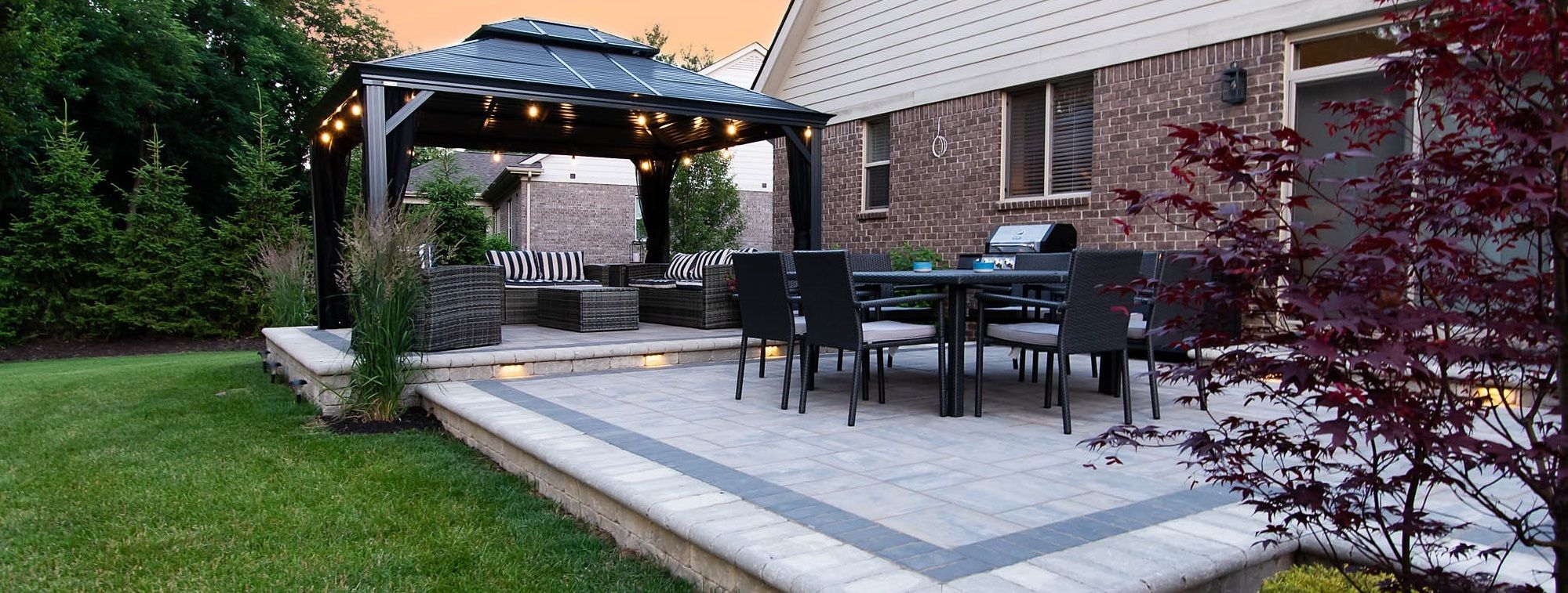 Brick patio with gazebo, table, and chairs.